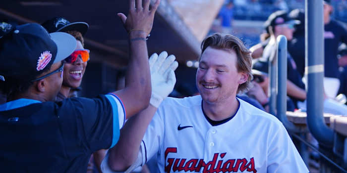 Cleveland Guardians prospect Kyle Manzardo high-fives his teammates.